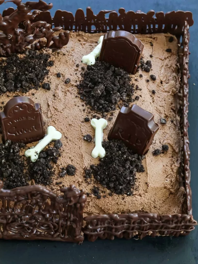 Cake decorated with chocolate shaped designs for a halloween graveyard.