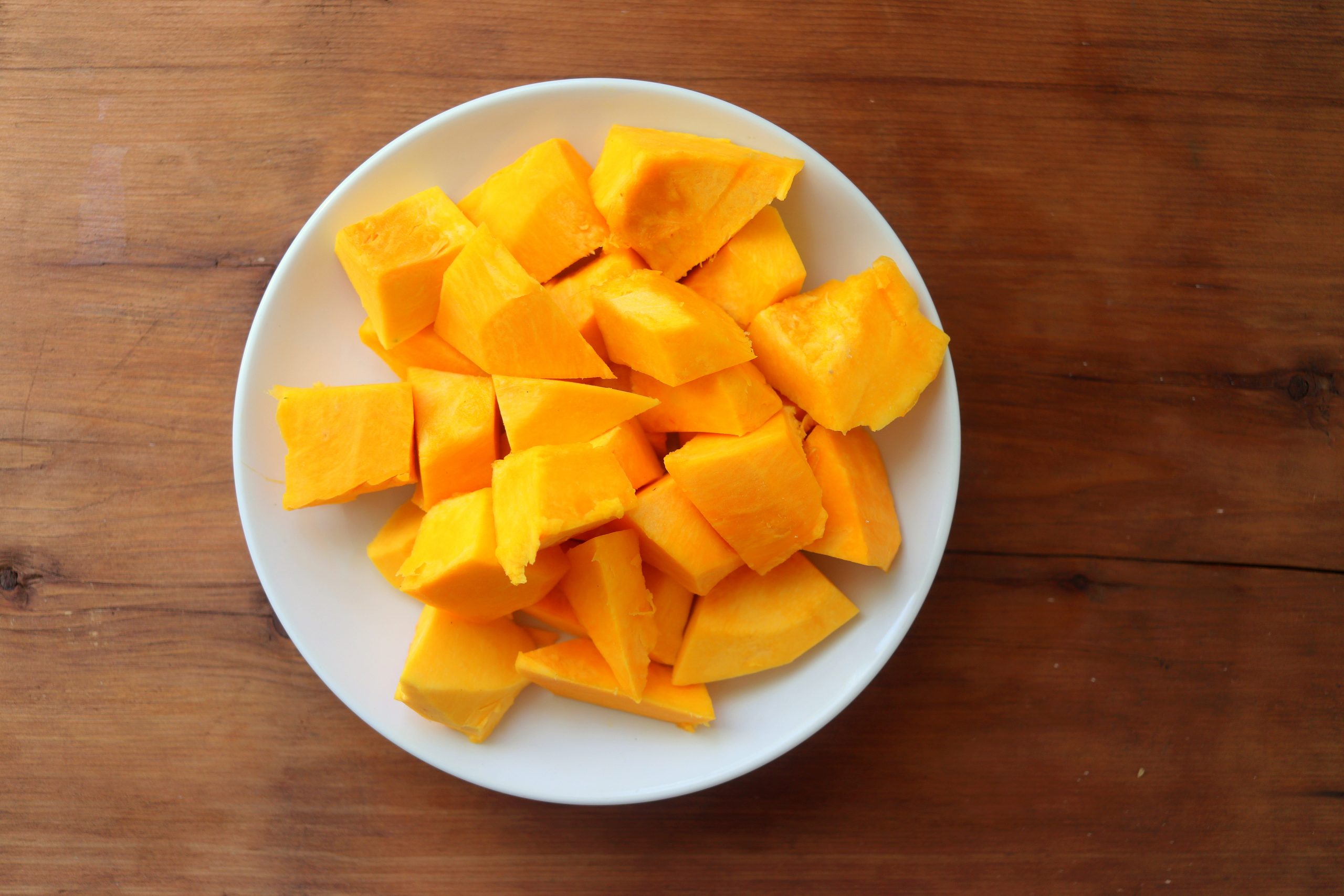 A plate filled with diced chunks of squash.