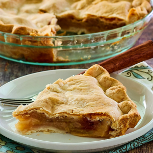 Sideview of a slice of pie with the cut whole pie in the background