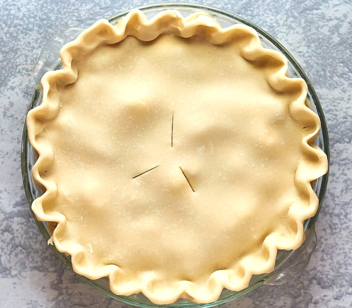 Top down view of a double pie crust pie with fluted edges.
