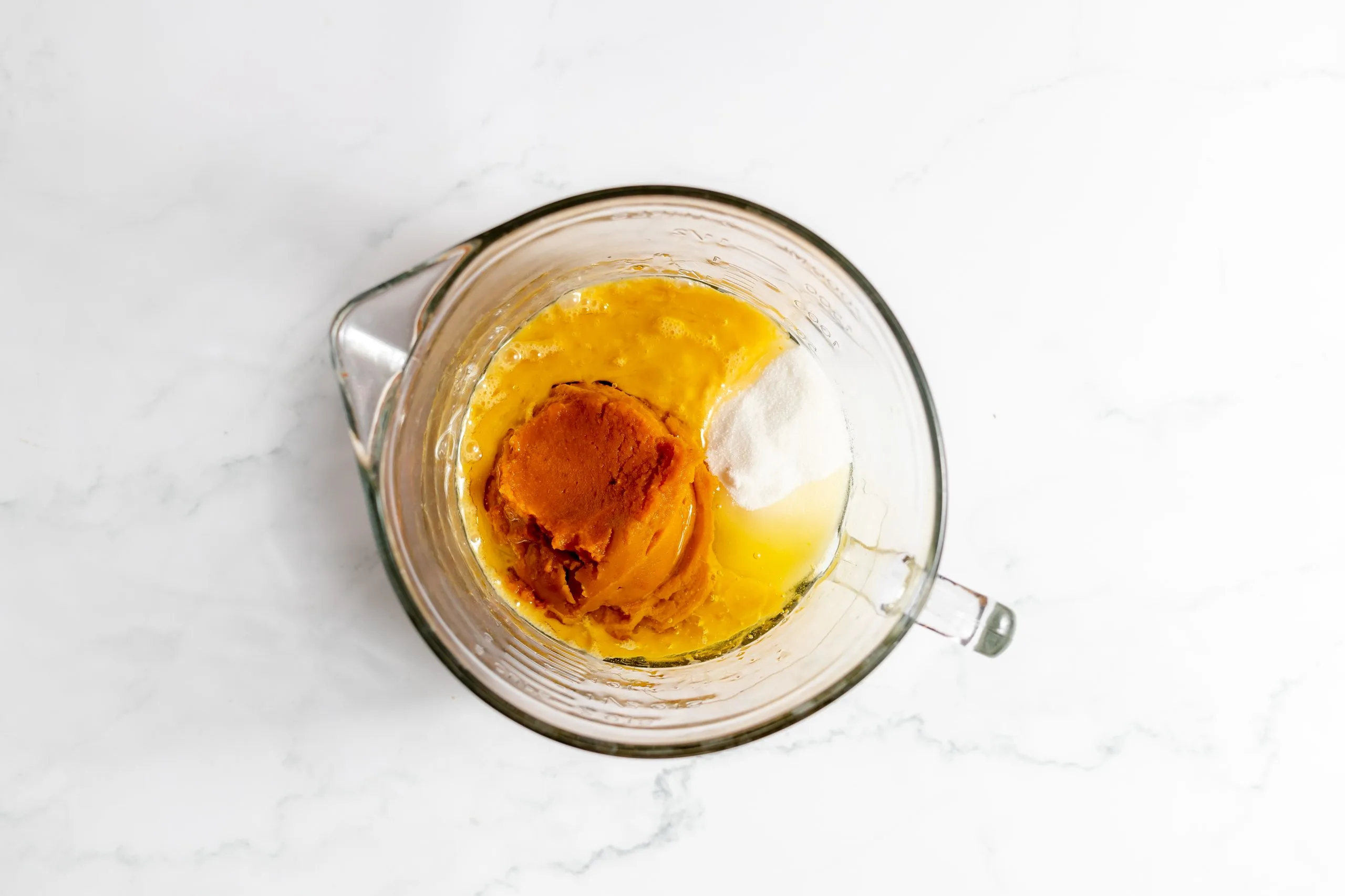 Wet pumpkin bread ingredients combined in a measuring cup