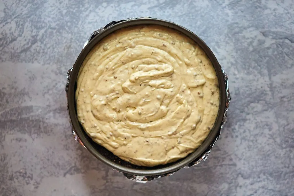 Cheesecake filling spread evenly in the pan.