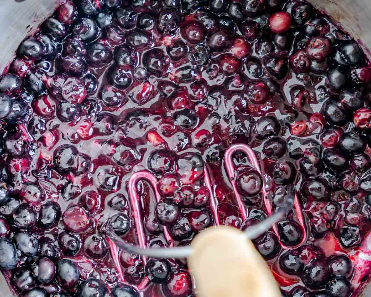 Fresh cooked blueberries mashed with a potato masher.