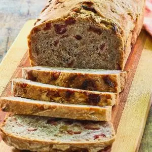 Front view of a sliced loaf of walnut cranberry bread.
