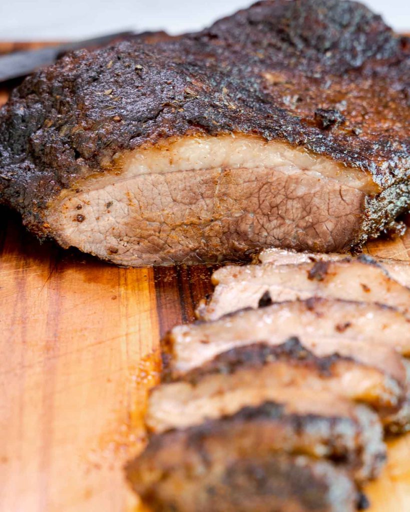 Front image of a sliced juicy Beef Brisket with a dark dry rubbed crust.