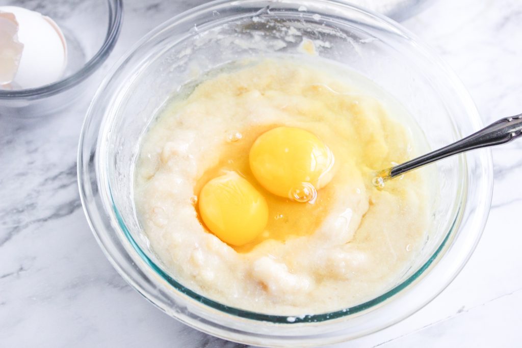 Two eggs mixed into banana muffin batter.