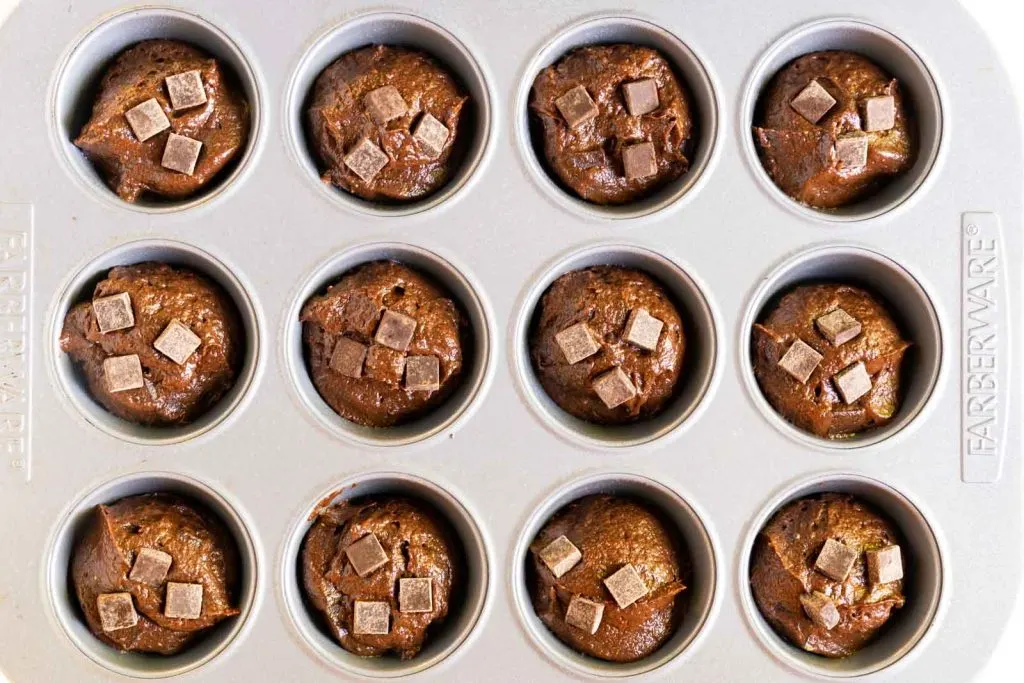 Top down view of a muffin tin filled Chocolate Chip Pumpkin Muffin Recipe batter