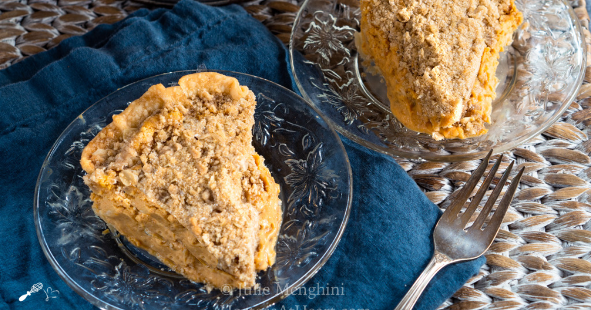 Top down image of two slices of cheesecake pie with pumpkin filling and a crumble top.