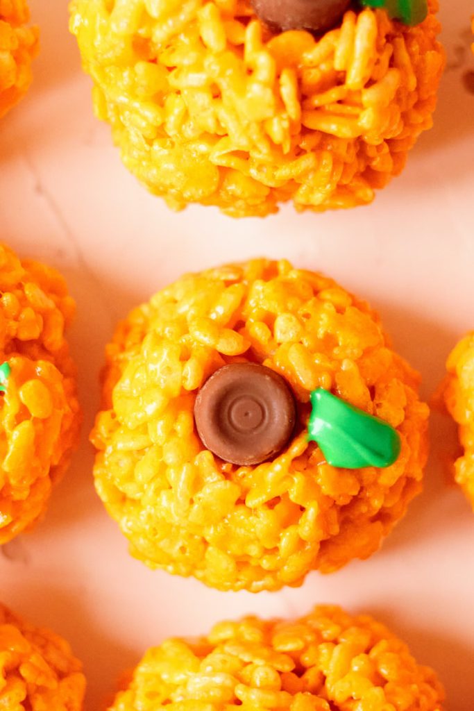 Rice Krispie treats shaped as pumpkins with a candy stem and frosting leaf.