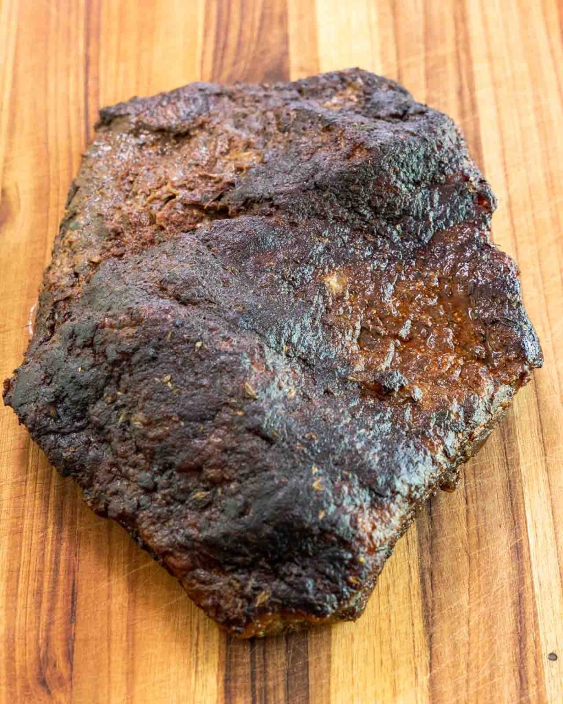 Top down view of a whole oven baked brisket with a thick crusty dry rubbed bark.