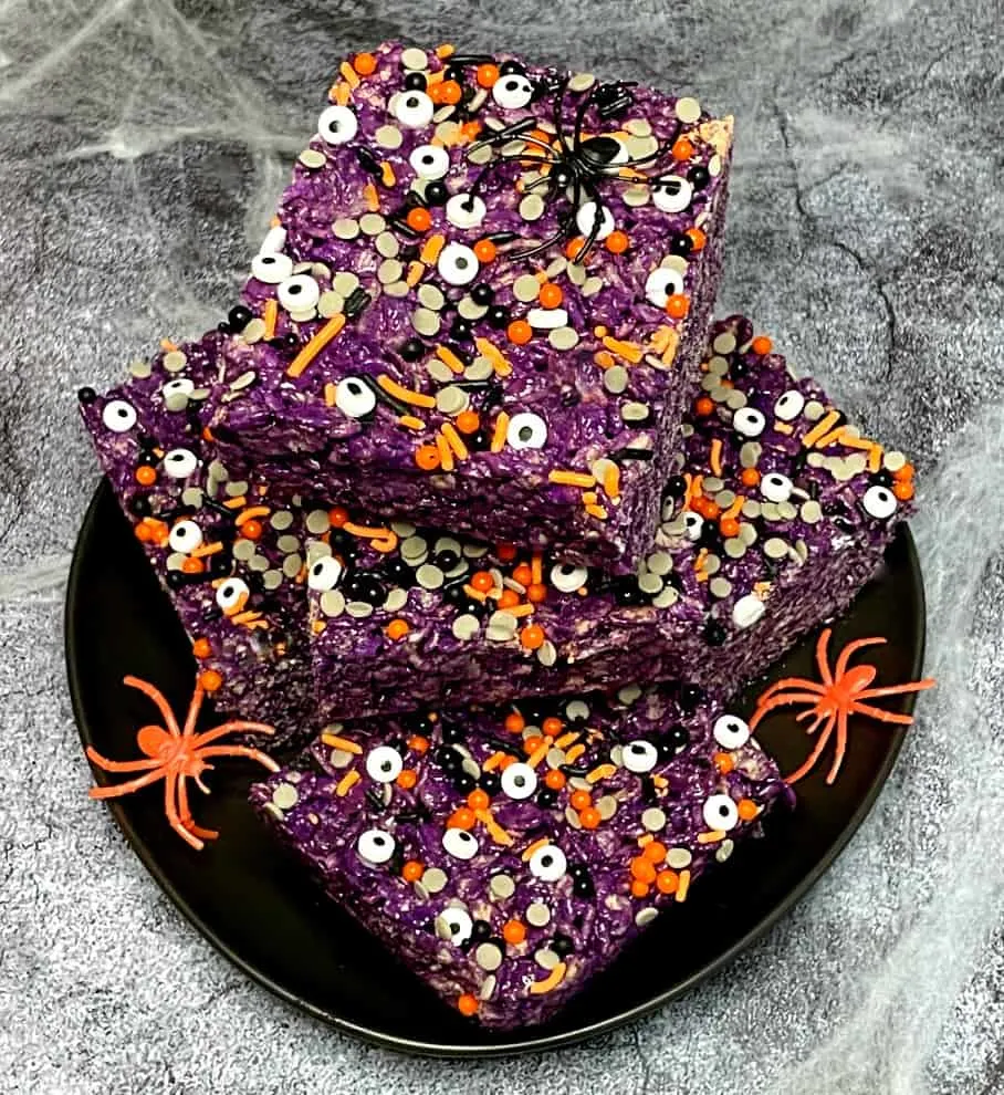Purple colored rice krispie squares with monster eyeballs.
