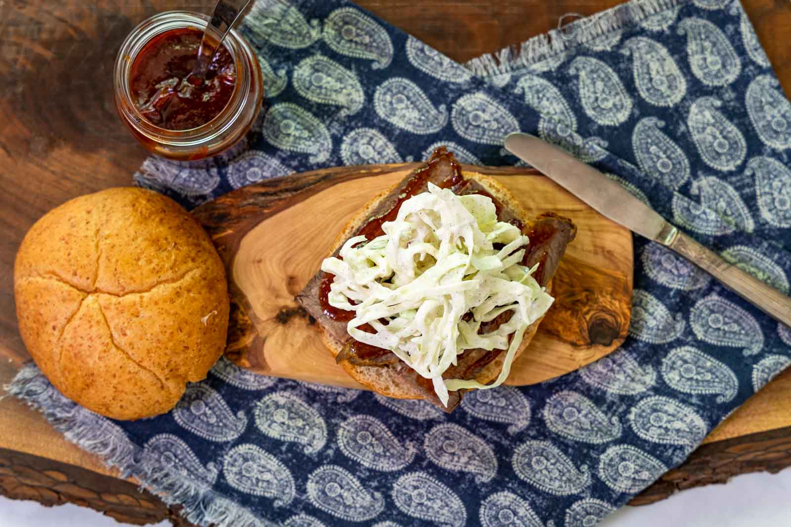 Top down view of a bun topped with brisket that's been slathered in bbq then topped with slaw.
