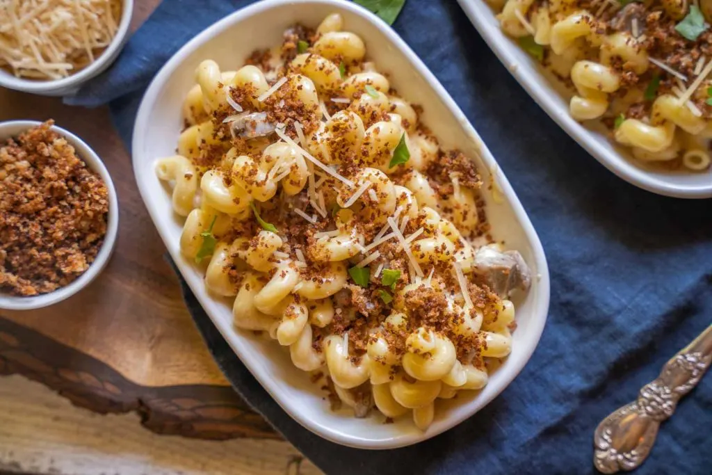 Top down view of cavatappi pasta in a cheese sauce combined with chunks of brisket then topped with toasted bread crumbs.