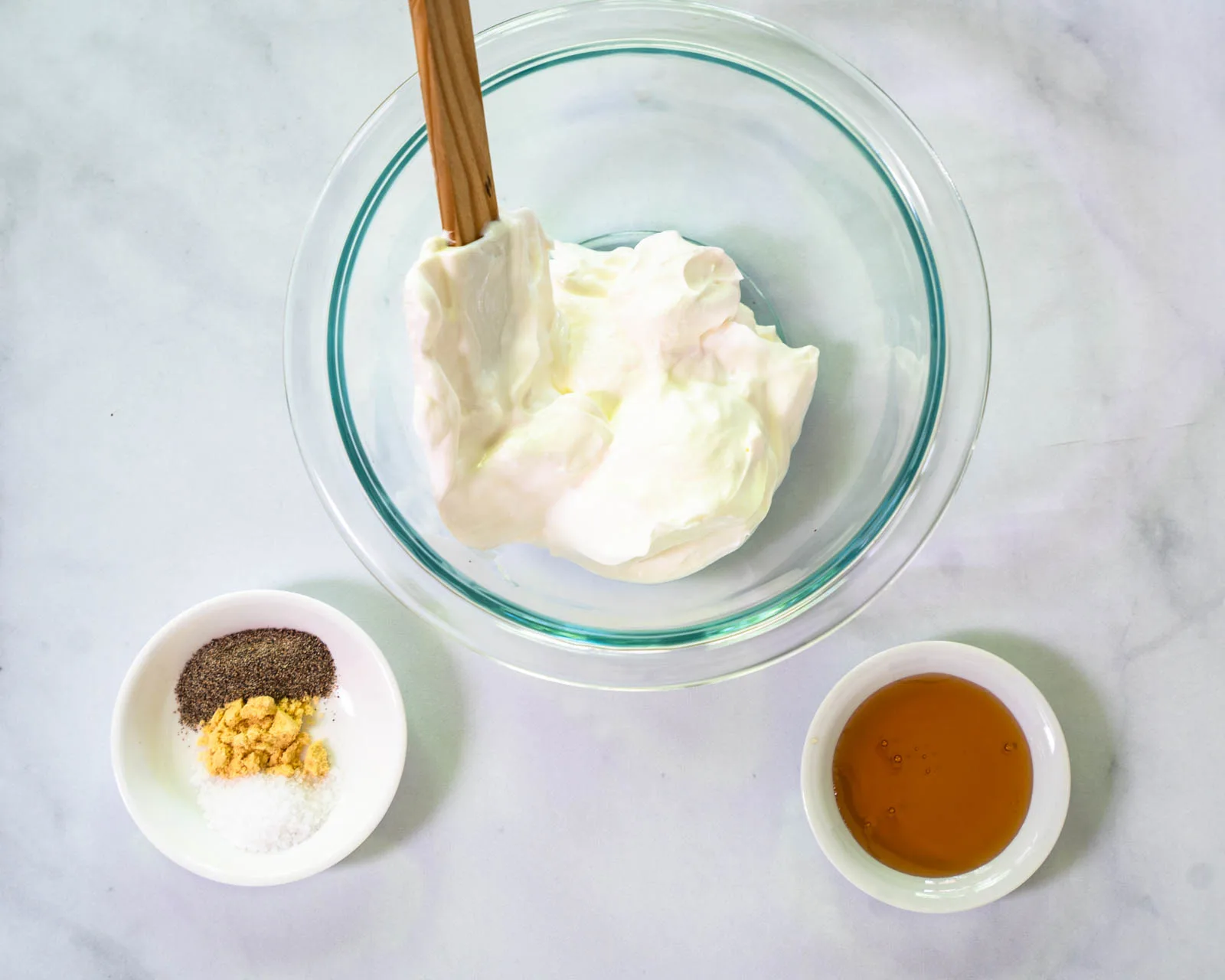 The ingredients used to make fennel slaw including spices, honey and sour cream.