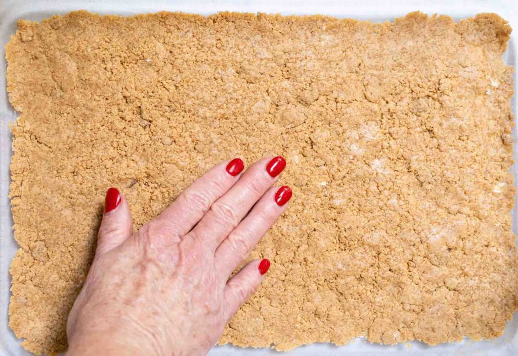 Peanut butter crust pressed into the bottom of a baking dish for a cream cheese peanut butter dessert