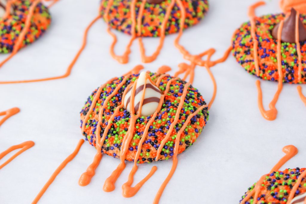 Baked thumbprint cookies with an orange glaze drizzled over the top for Halloween