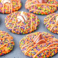 3/4 view of cookies covered in Halloween colored sprinkles with Hershey's Kisses pressed into the center.