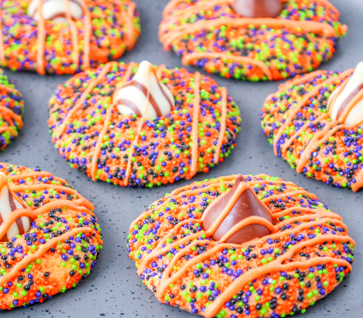 3/4 view of cookies covered in Halloween colored sprinkles with Hershey's Kisses pressed into the center.