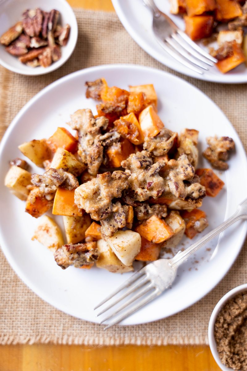 A plate filled with recipe for sweet potato casserole topped with a pecan topping.