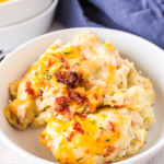 Close up image of creamy potatoes topped with bacon and cheese.