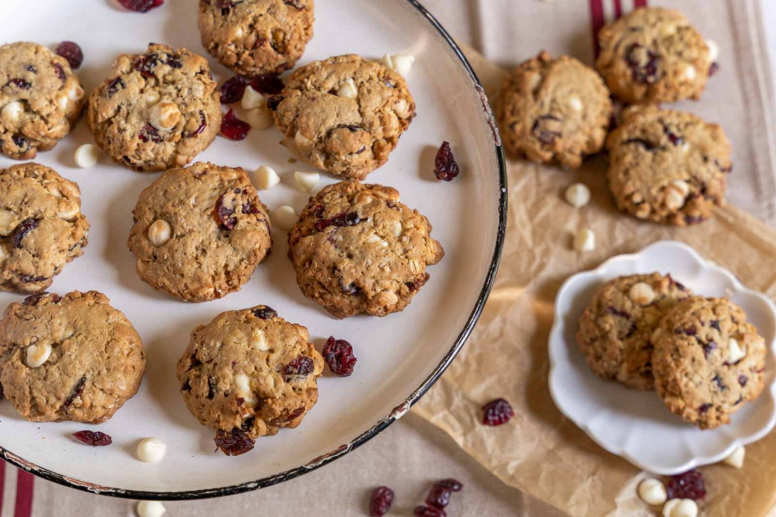 Top down view of White Chocolate Cranberry Cookies on a platter and plate.