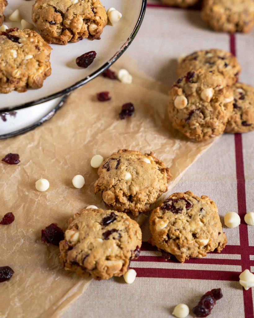 White chocolate cranberry oatmeal cookies on a piece of brown parchment paper. 