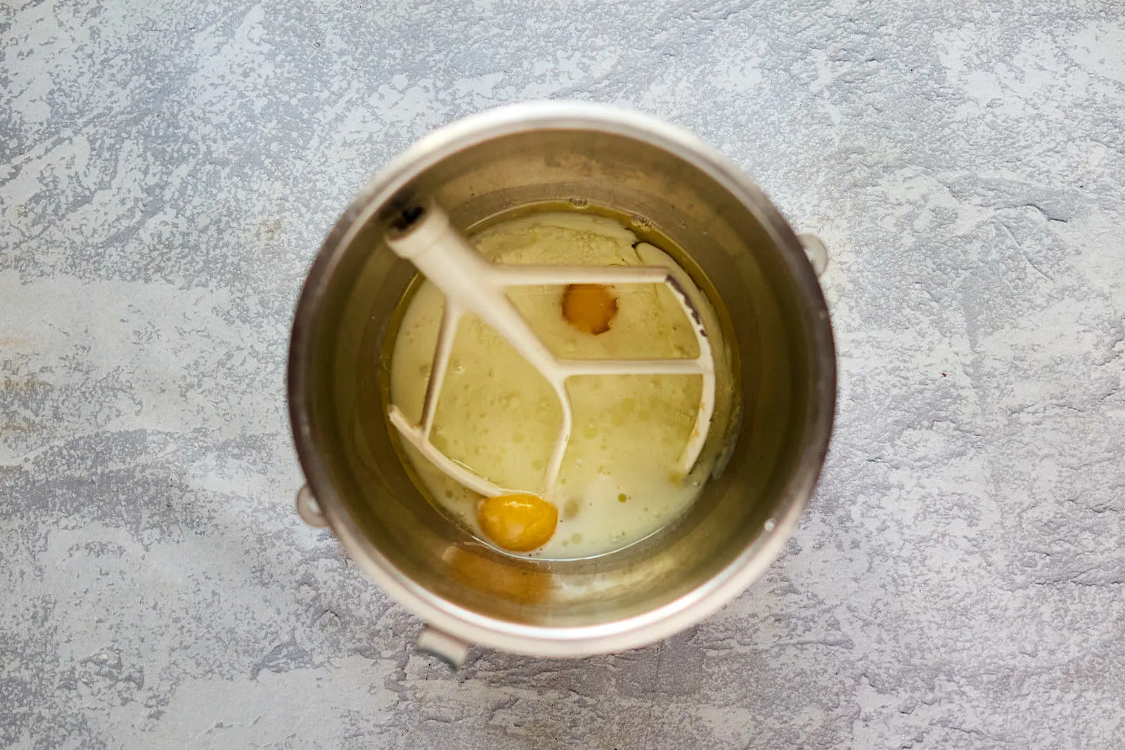 Wet ingredients in a mixing bow including eggs, oil, and buttermilk,