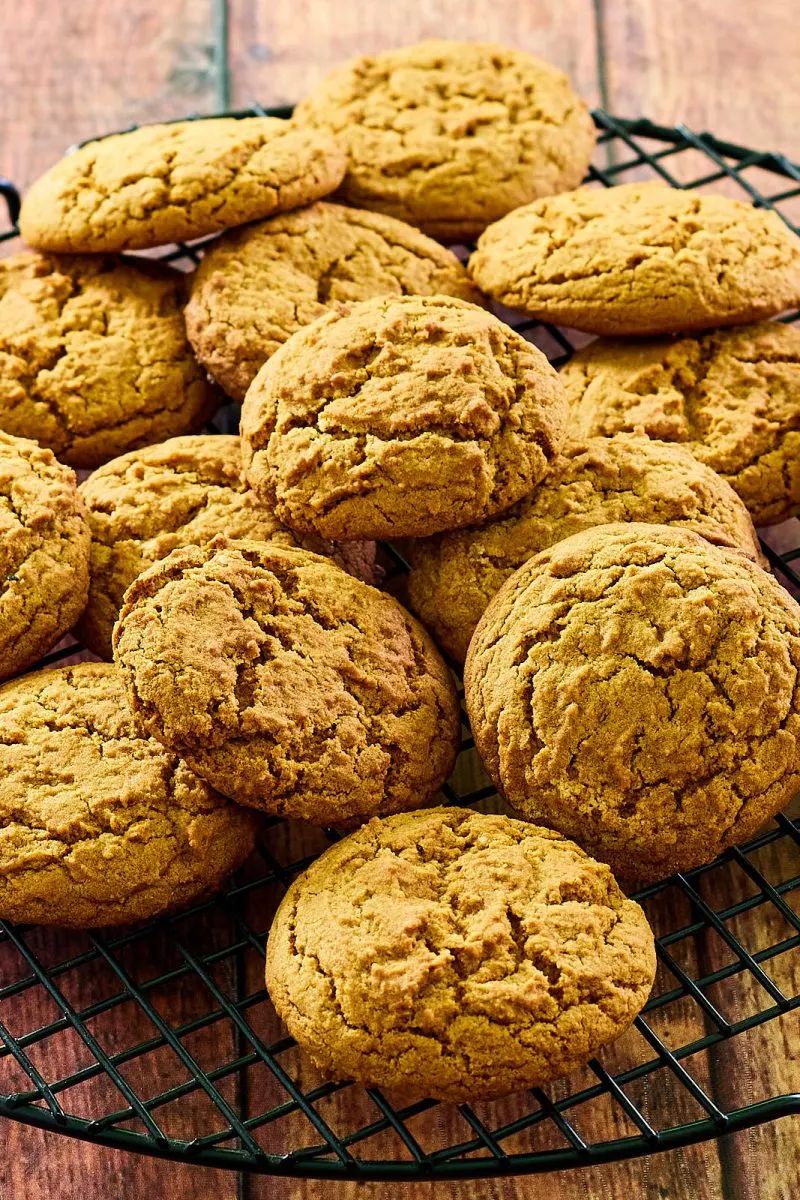 Soft ginger bread cookies stacked on a cooling rack.