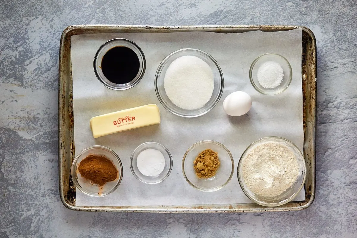 Gingerbread cookie ingredients including molasses, butter, cinnamon, ginger, baking soda, salt, flour, eggs, and sugar.