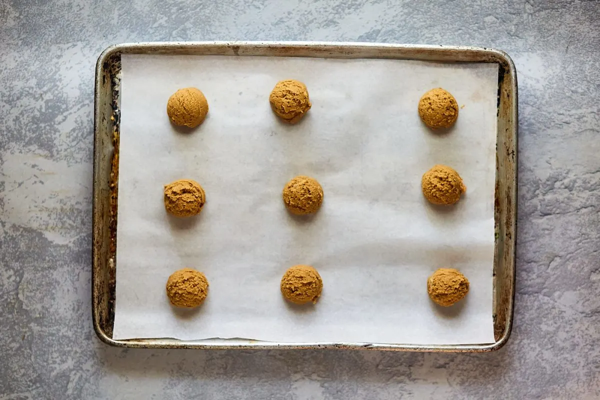 Top down view of shaped gingerbread cookie dough on a baking sheet pan.