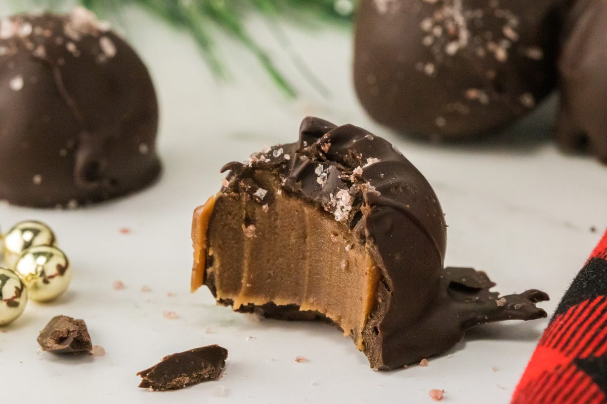 Close-up of single salted caramel truffle with a bite missing.