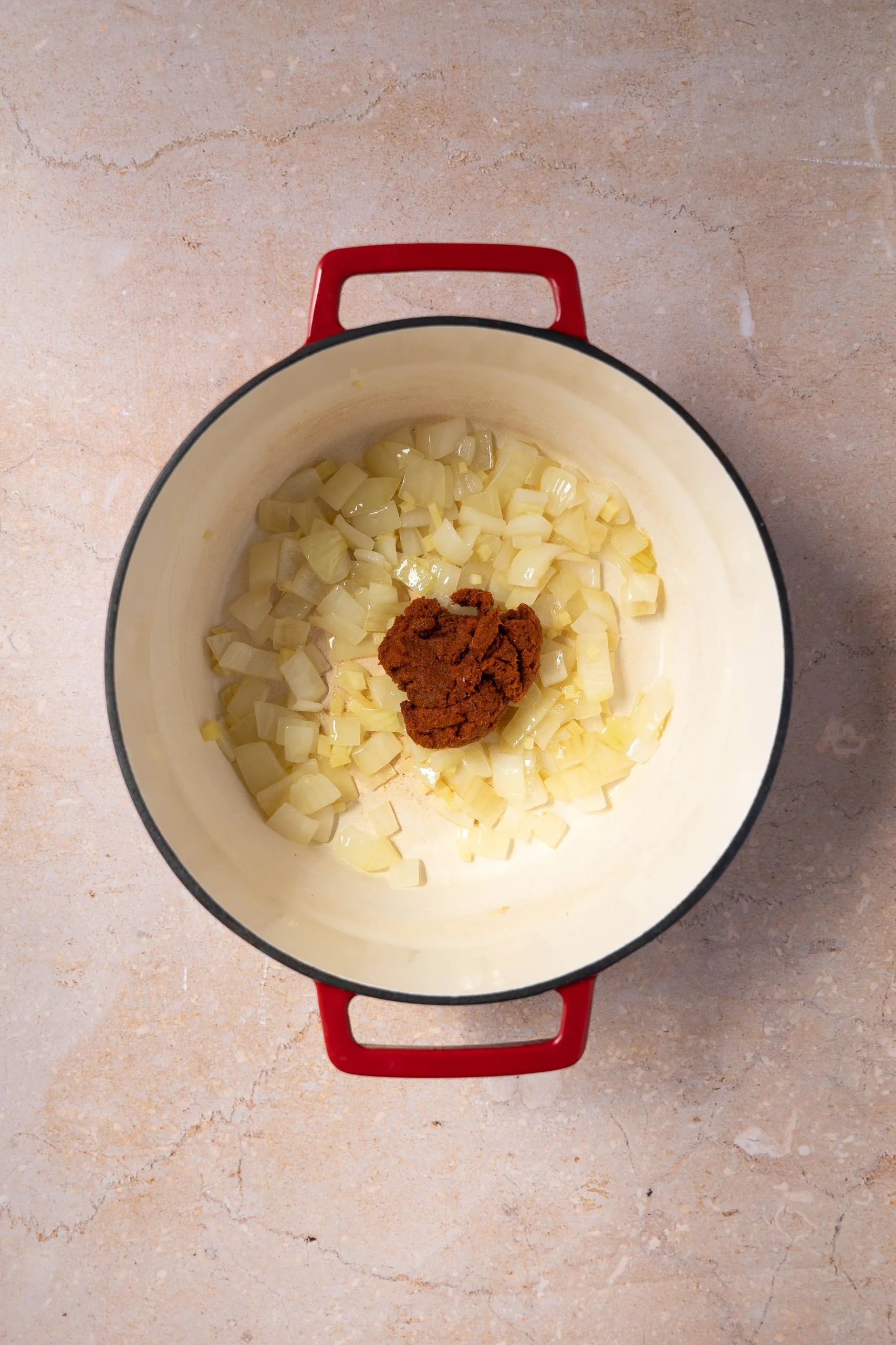 Dutch oven filled with sauteed onion and red curry