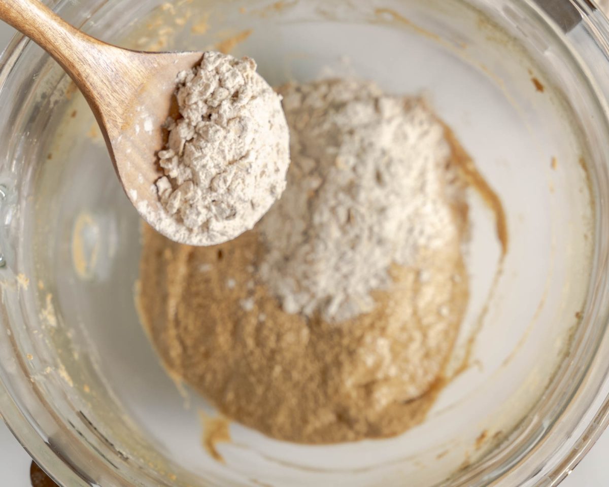 Dry ingredients being added to wet cranberry cookie dough batter.