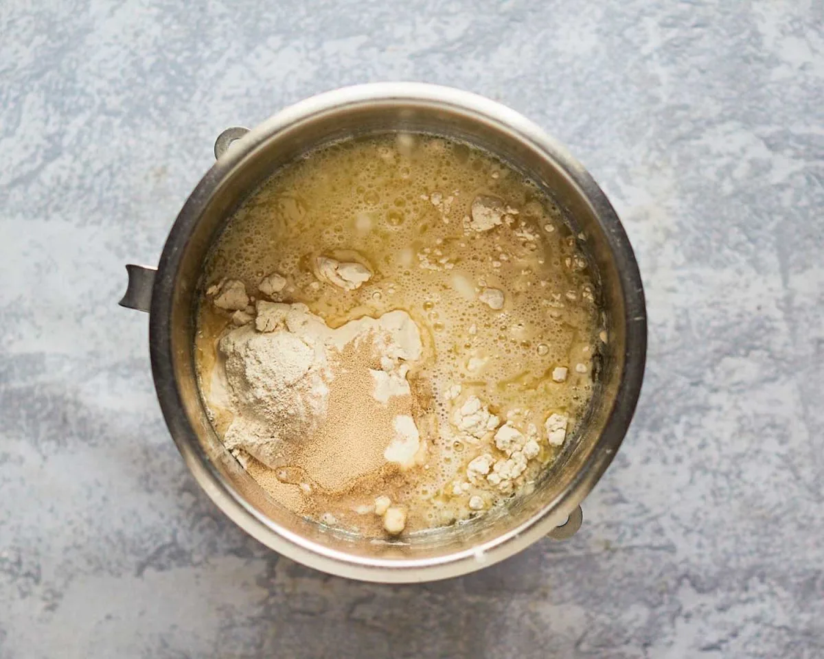 Cinnamon roll dough ingredients added to the bowl of an electric mixer - hostess at heart