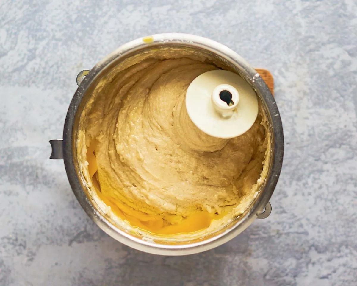 Cinnamon Roll Dough mixed with a dough hook and mixing bowl of an electric mixer - hostess at heart