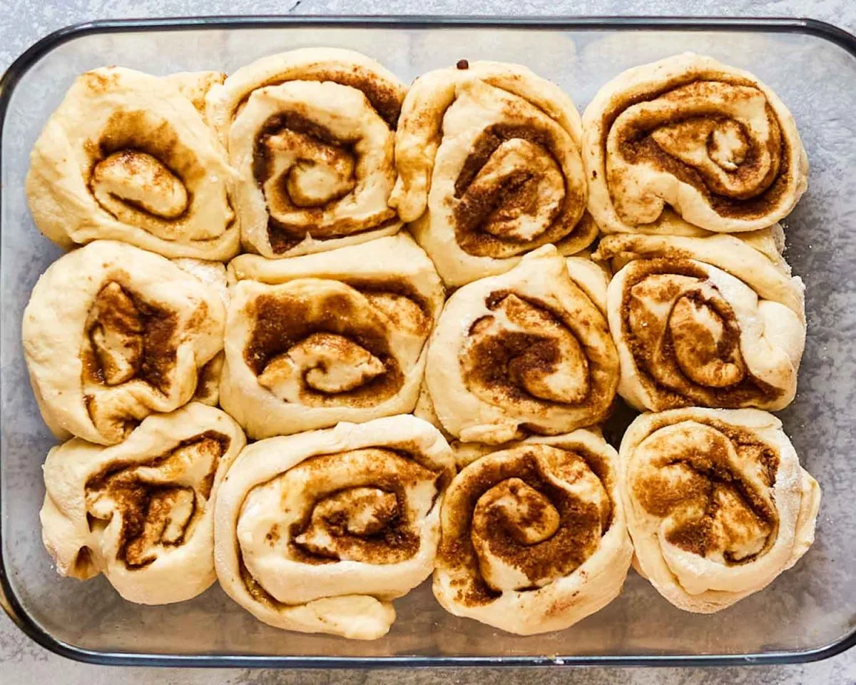 A baking dish filled with unbaked homemade cinnamon rolls - Hostess At Heart