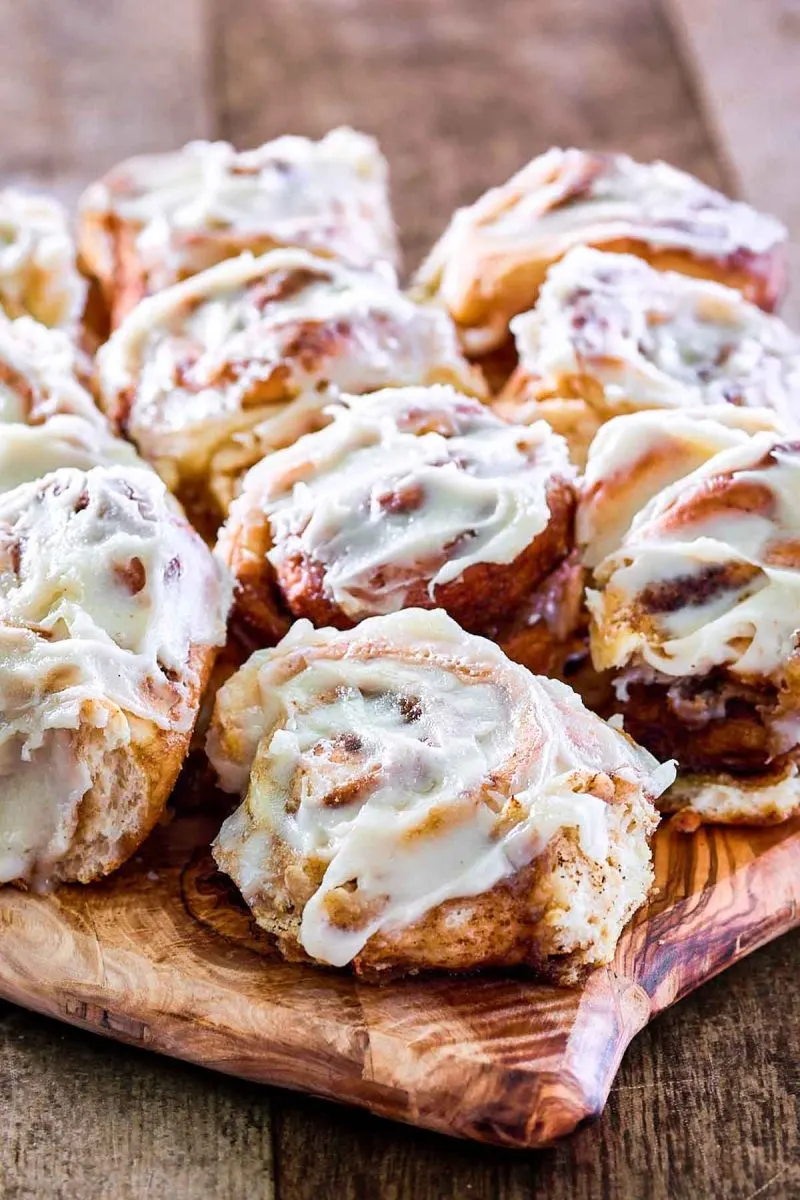 Soft and tender rolls made from a recipe for cinnamon rolls sitting on a cutting board - Hostess At Heart