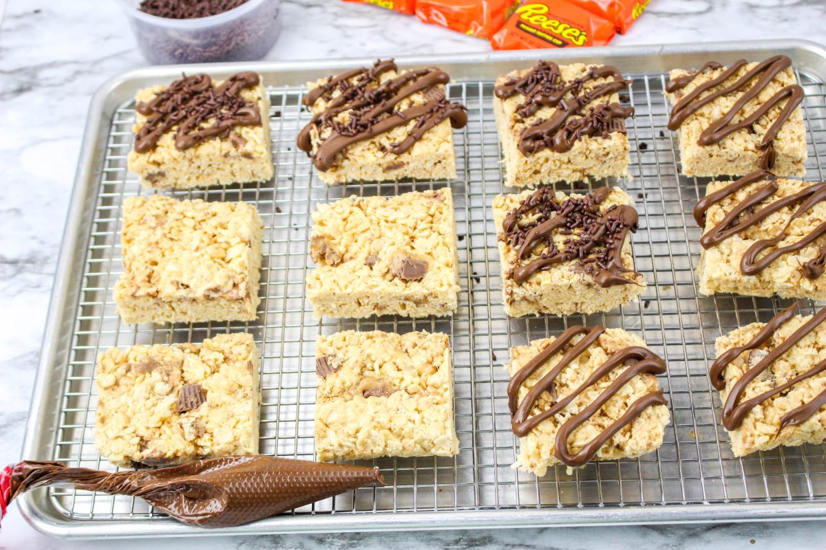 peanut butter rice krispe bars as they are being drizzled with melted chocolate peanut butter candy.