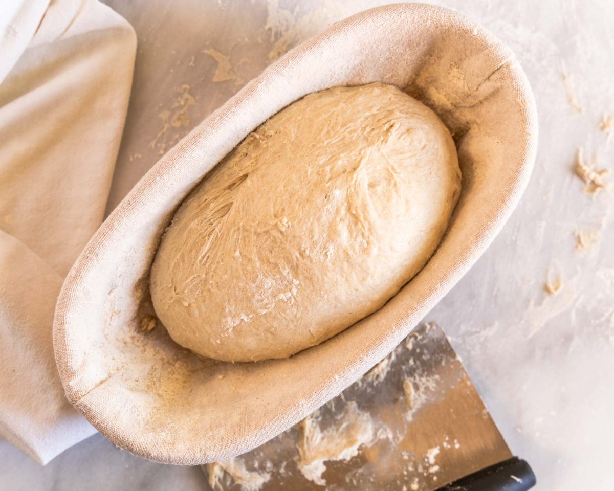 Shaped bread dough sitting in a banneton basket - Hostess At Heart
