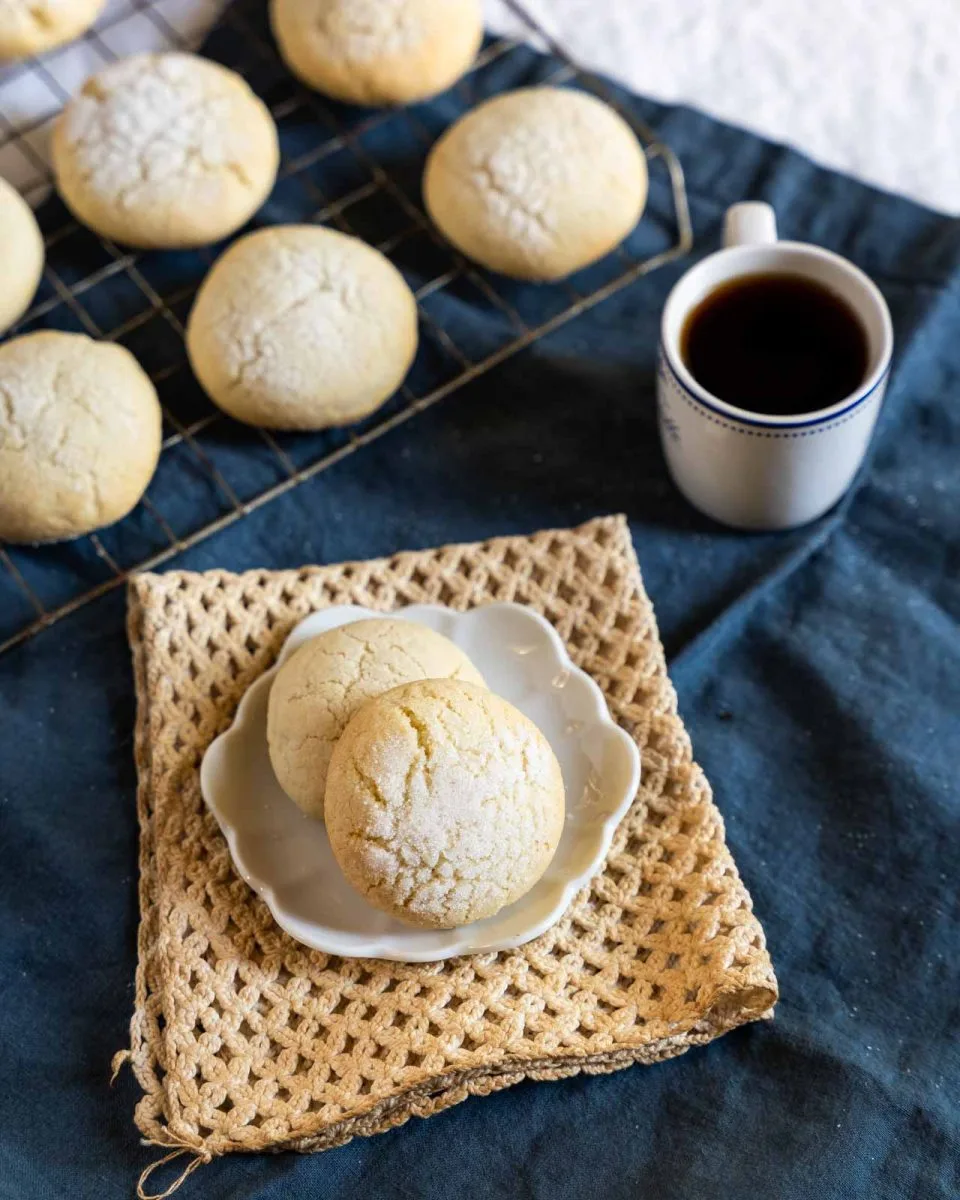 Angled view of two cookies made from a sour cream cookie recipe sitting on a white plate. Hostess At Heart