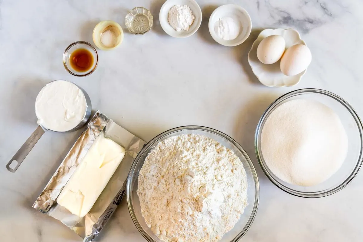 Ingredients used to make a sour cream cookie recipe including shortening, sour cream, flour, sugar, egg, vanilla, baking soda, baking powder, eggs, vanilla extract, salt, and lemon extract. Hostess At Heart