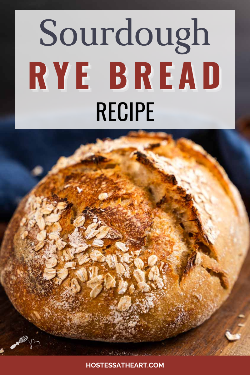 Front view of a loaf of rye sourdough bread topped with oats sitting on a cutting board. - Hostess At Heart