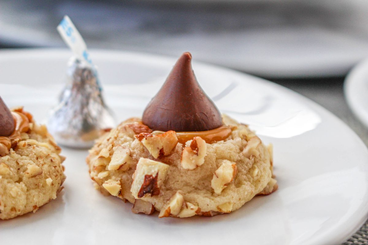 A tableview of a caramel filled turtle thumbprint cookie topped with a chocolate candy kiss. Hostess At Heart
