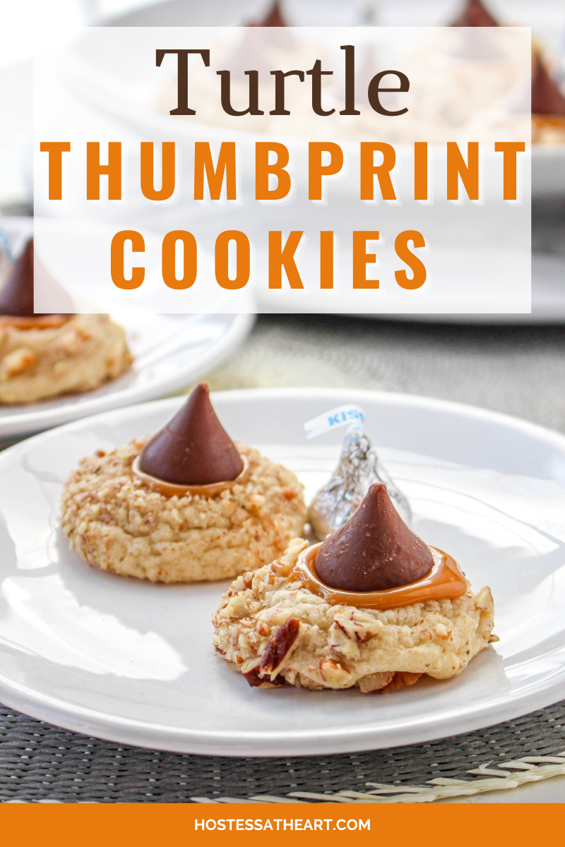 Two thumbprint cookies sitting on a plate that were covered in nuts and filled with caramel and topped with a chocolate kiss. Hostess At Heart