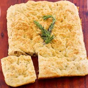 Top down view of baked Italian focaccia sitting on a cutting board - Hostess At Heart