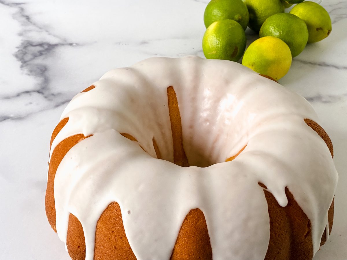 Angled view of a Key Lime Bundt Pound Cake drizzled with lime glaze. Hostess At Heart