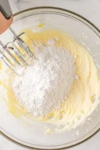 Dry cake ingredients added to creamed mix in a bowl - Hostess At Heart