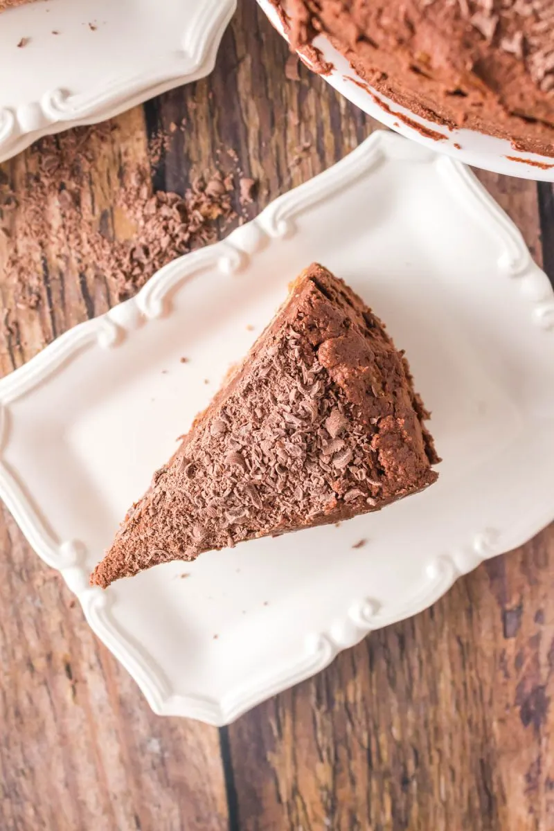 Top-down view of a slice of Mahogany Chocolate Cake sitting on a white serving plate - Hostess At Heart