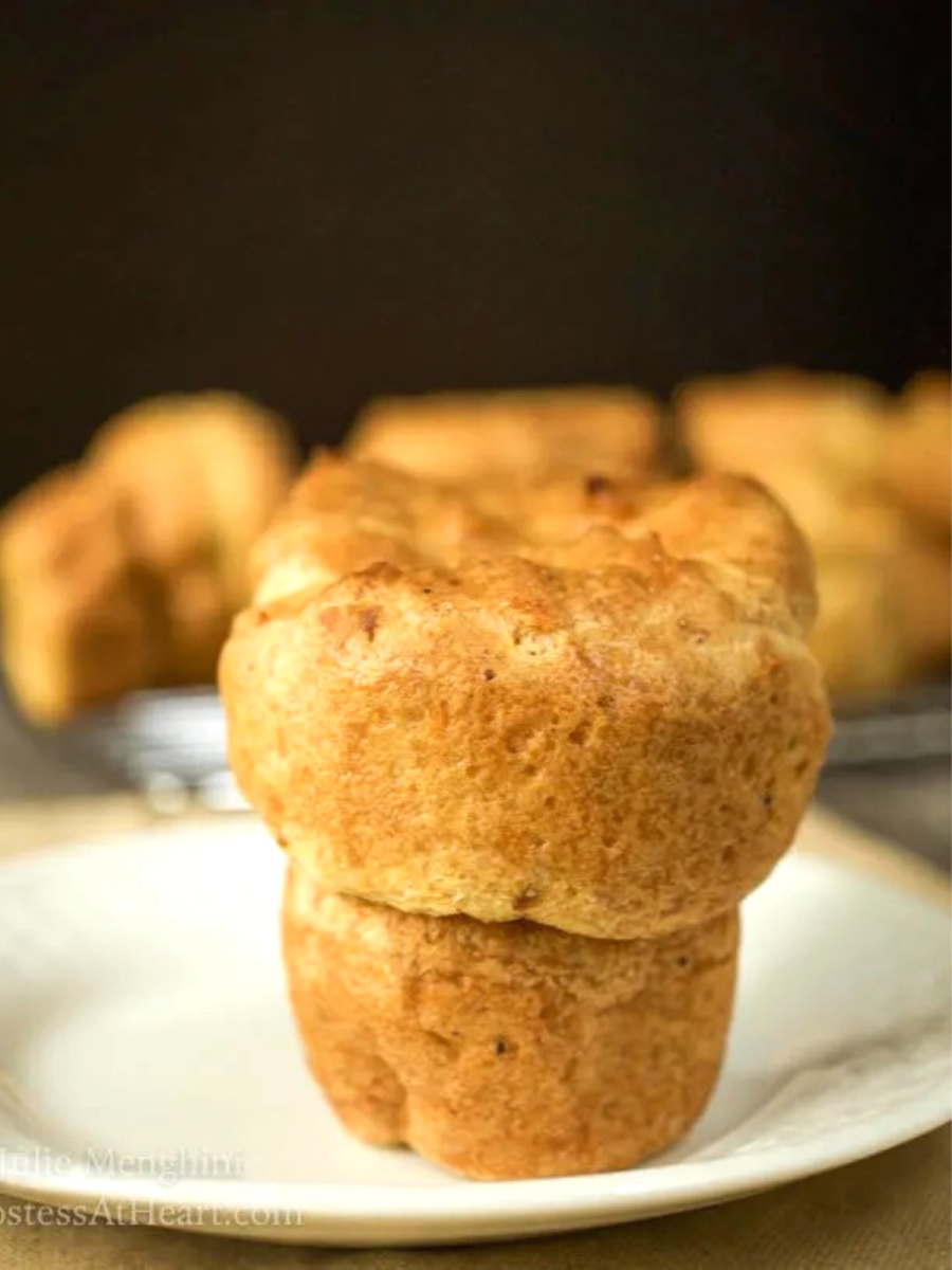 Side view of a baked popover sitting on a white plate - Hostess At Heart