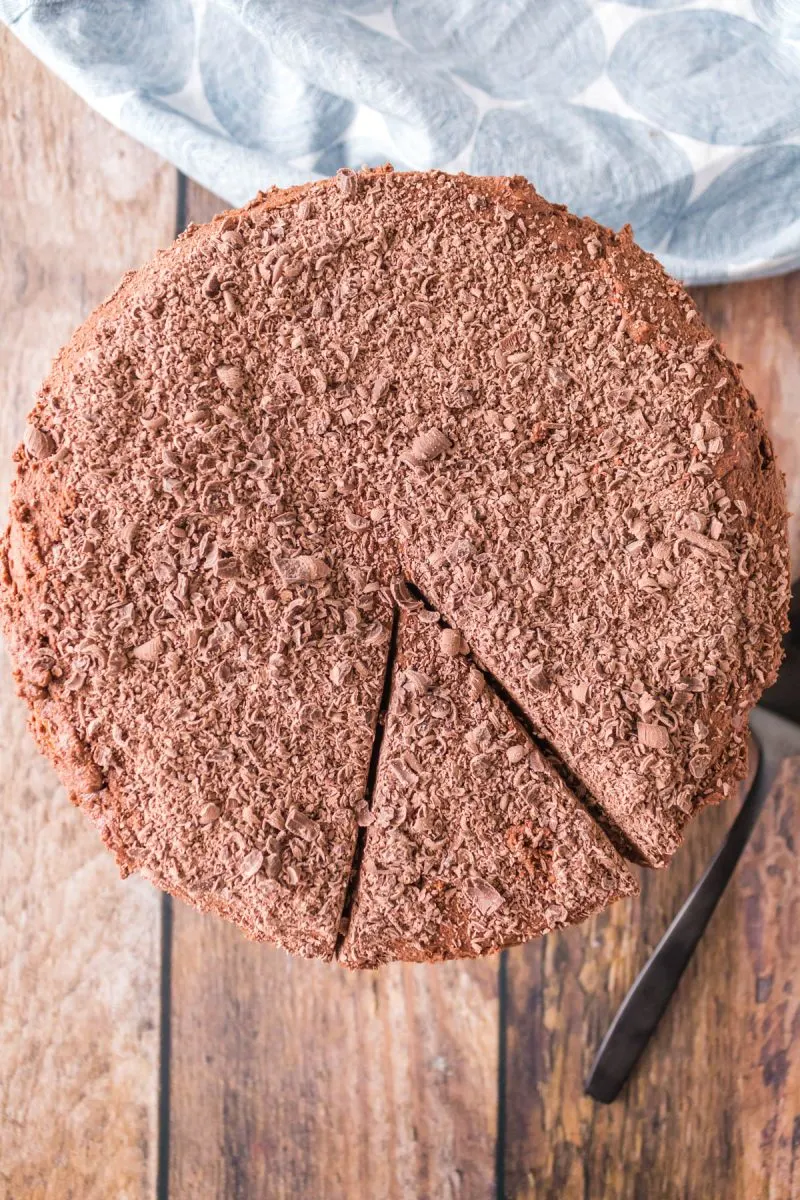 Top-down view of a round Mahogany Layered cake covered with grated chocolate. Hostess At Heart